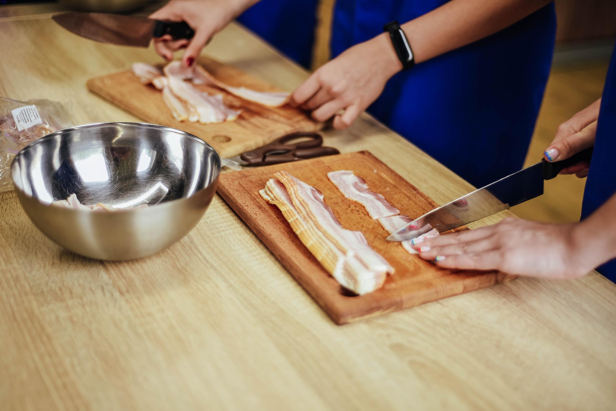 Students around kitchen bench learning knife skills